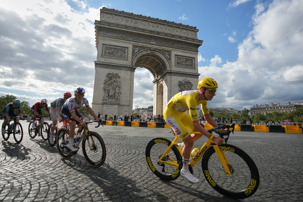 Slovenia's Tadej Pogacar, wearing the overall leader's yellow jersey, rides in front of the Arc de Triomphe during the last stage of the Tour de France cycling race with start and finish in Paris, Sunday, July 26, 2026. (AP Photo/Mosa'ab Elshamy)
