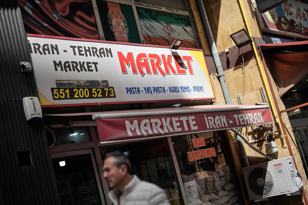A man walks past an Iranian grocery shop in Istanbul on Tuesday, April 14, 2026. (AP Photo/Khalil Hamra)