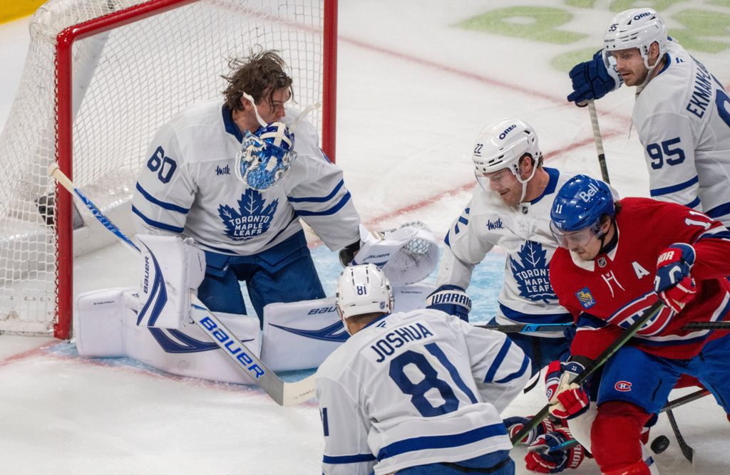 Toronto Maple Leafs goaltender Joseph Woll (60) loses his mask as Montreal Canadiens' Brendan Gallagher (11) looks for the rebound defended by Maple Leafs' Jake McCabe (22) during the first period of an NHL hockey game in Montreal on Tuesday, March 10, 2026. (Christinne Muschi/The Canadian Press via AP)