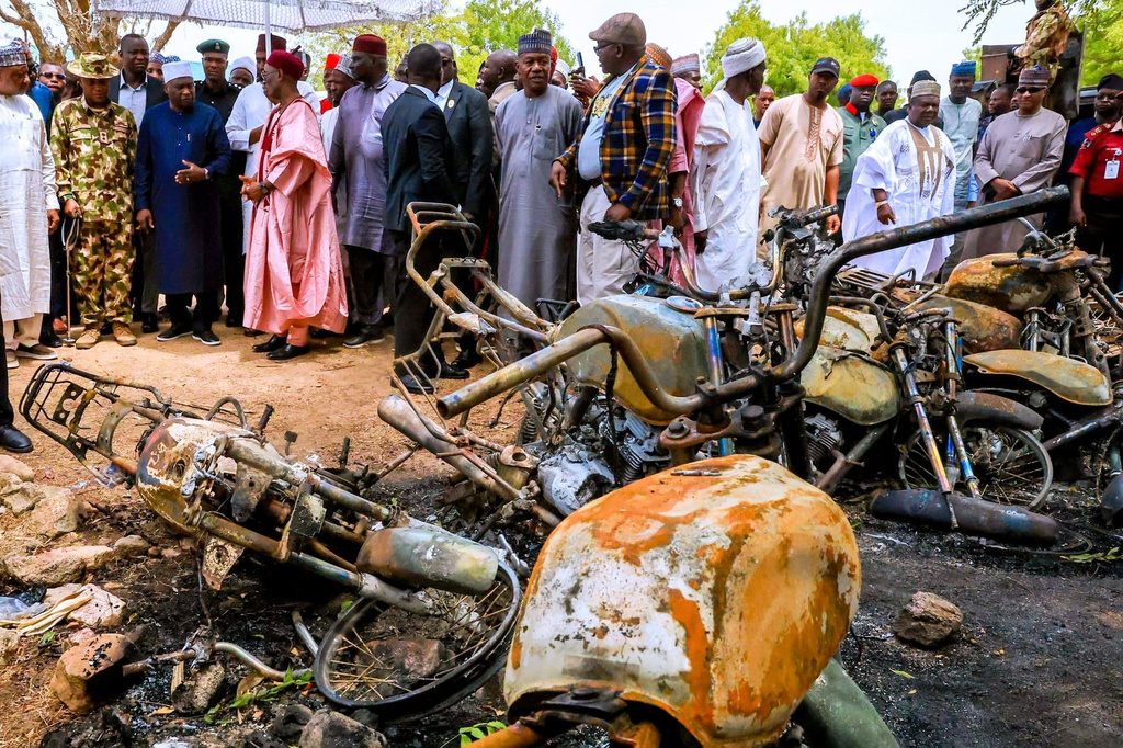In this photo, released by Adamawa State Government House, Adamawa State Governor Ahmadu Umaru Fintiri, left white hat, inspects an area in Guyaku, northeastern Nigeria, Monday, April 27, 2026, that was attacked by Militants with the Islamic State group on Sunday. (Adamawa state government house via AP)
