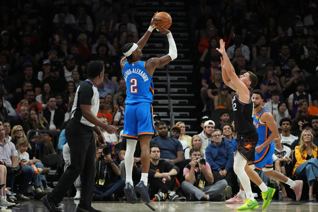 Oklahoma City Thunder guard Shai Gilgeous-Alexander (2) shoot a 3-pointer against Phoenix Suns guard Collin Gillespie (12) during the first half of Game 4 in a first-round NBA playoffs basketball series, Monday, April 27, 2026, in Phoenix. (AP Photo/Ross D. Franklin)