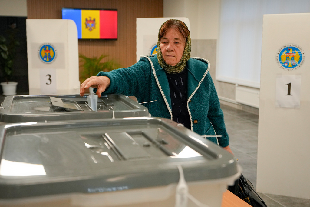 A woman casts her vote during a parliamentary election, in Chisinau, Moldova, Sunday, Sept. 28, 2025. (AP Photo/Vadim Ghirda)