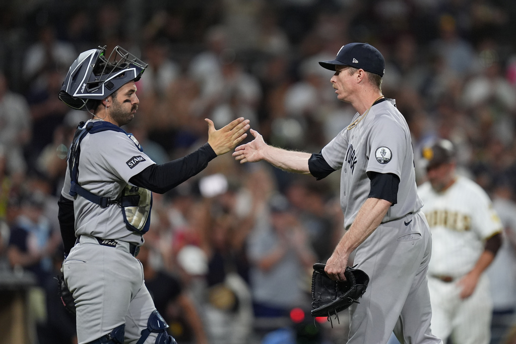 New York Yankees pitcher Tim Hill, right, celebrates with catcher Austin Wells after the Yankees defeated the San Diego Padres 5-1 in a baseball game Saturday, Sept. 5, 2026, in San Diego. (AP Photo/Gregory Bull)