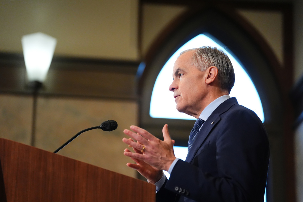 Prime Minister Mark Carney, left, holds a press conference in Ottawa on Tuesday, April 14, 2026. (Sean Kilpatrick/The Canadian Press via AP)