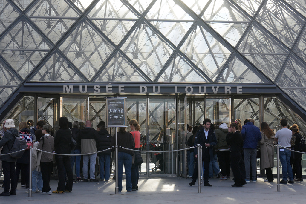 Visitors queue to enter the Louvre museum three days after historic jewels were stolen in a daring daylight heist, Wednesday, Oct. 22, 2025 in Paris. (AP Photo/Thibault Camus)