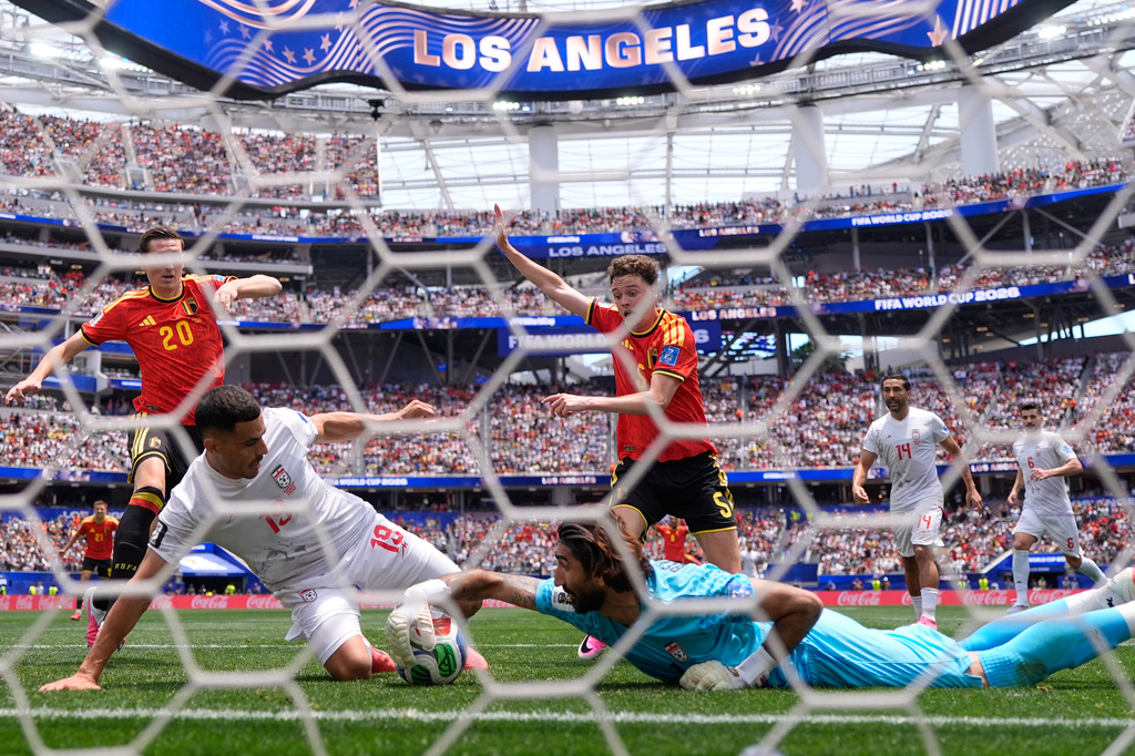 Iran goalkeeper Alireza Beiranvand (1) makes a save from Belgium's Maxim De Cuyper (5) during the World Cup Group G soccer match between Belgium and Iran in Inglewood, Calif., near Los Angeles, Sunday, June 21, 2026. (AP Photo/Mark J. Terrill)