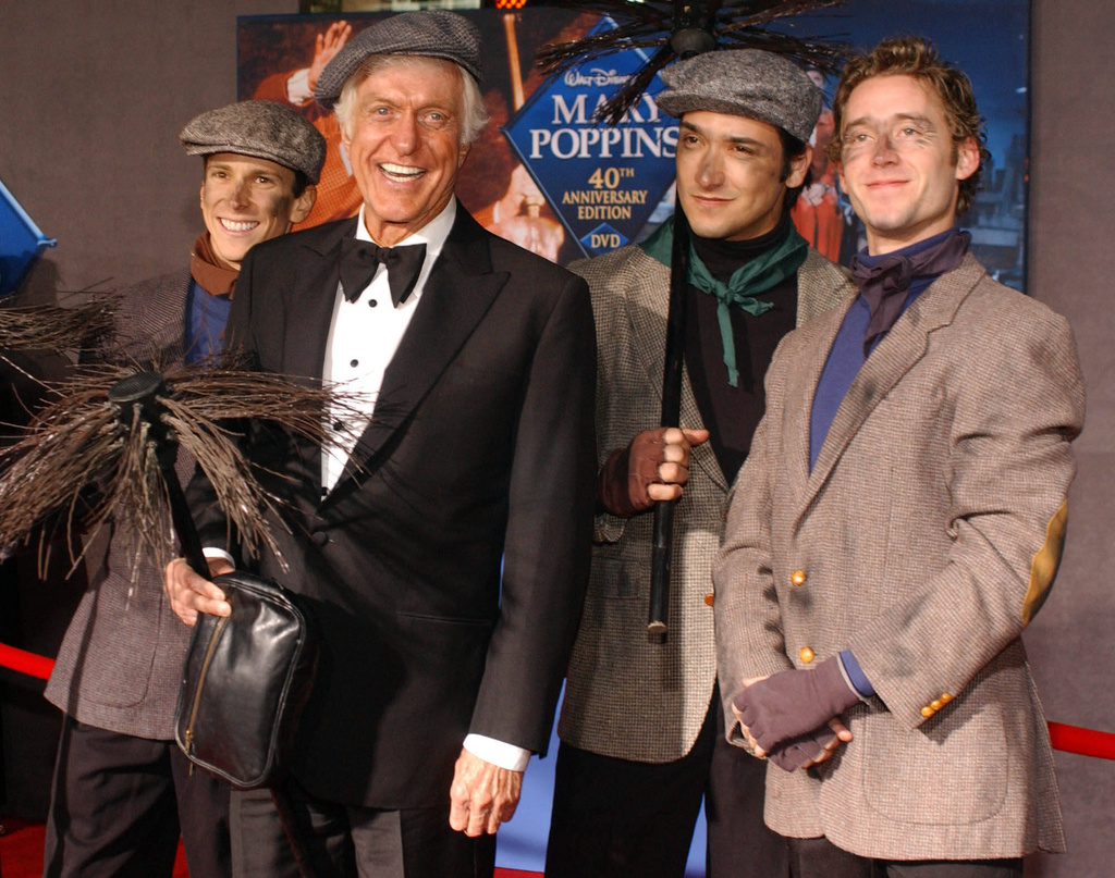 FILE - Dick Van Dyke poses with chimney sweeps during arrivals to the 40th anniversary and re-premiere of Mary Poppins at the El Capitan Theatre in Los Angeles, Tuesday, Nov. 30, 2004. (AP Photo/Ann Johansson, File)