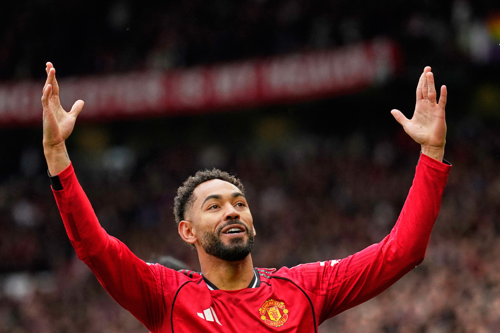 Manchester United's Matheus Cunha celebrates after scoring his side's opening goal during the English Premier League soccer match between Manchester United and Liverpool in Manchester, England, Sunday, May 3, 2026. (AP Photo/Dave Thompson)