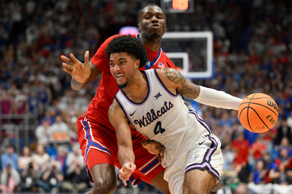 FILE - Kansas State guard PJ Haggerty (4) drives past Kansas forward Flory Bidunga (40) during the second half of an NCAA college basketball game in Lawrence, Kan., Saturday, March 7, 2026. (AP Photo/Reed Hoffmann, File)