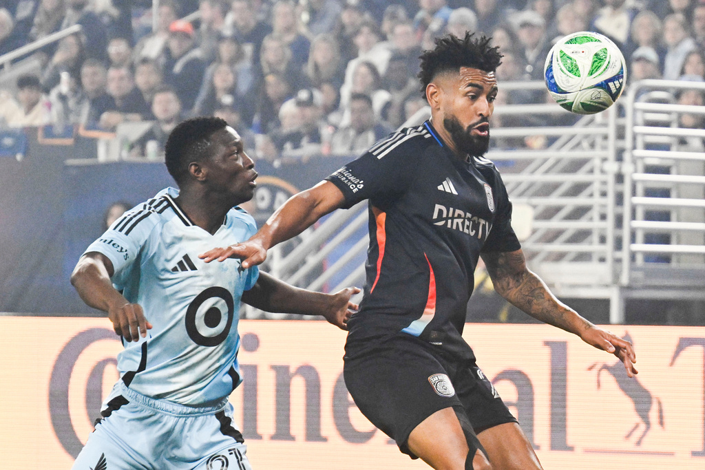 San Diego FC midfielder Anibal Godoy (20), right, fights for the ball with Minnesota United forward Bongokuhle Hlongwane (21) during the first half of MLS soccer's Western Conference semifinal Monday, Nov. 24, 2025, in San Diego. (AP Photo/Denis Poroy)