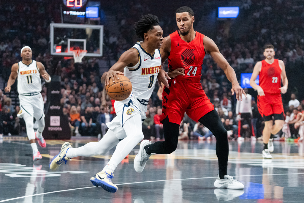 Portland Trail Blazers forward Kris Murray (24) attempts to defend against Denver Nuggets guard Peyton Watson (8) during the first half of an NBA Cup basketball game Friday, Oct. 31, 2025, in Portland, Ore. (AP Photo/Ali Gradischer)