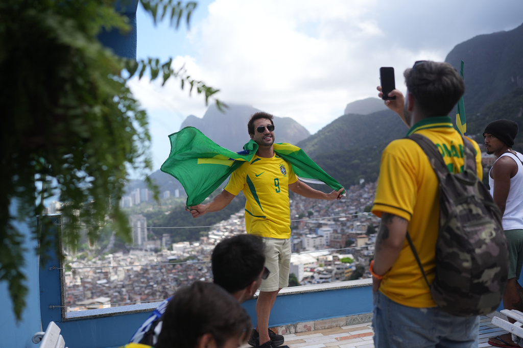 A tourist wearing a jersey in Brazilian colors poses for a photo at the Rocinha favela in Rio de Janeiro, on Sept. 2, 2026. (AP Photo/Silvia Izquierdo)