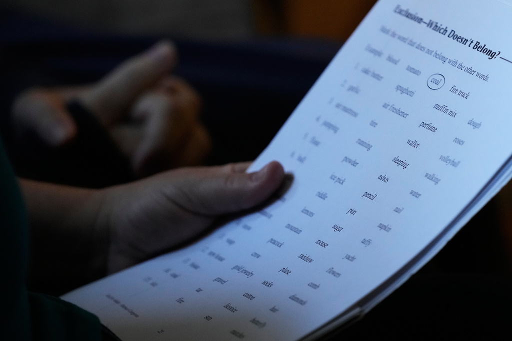 Martha Swick holds papers of study guide as she asked questions to her husband Bill Swick at their home in Minooka, Ill., Friday, Oct. 24, 2025. (AP Photo/Nam Y. Huh)