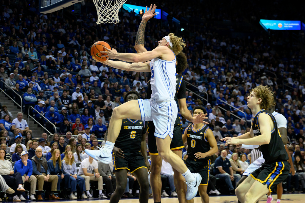 BYU guard Richie Saunders, center front, drives to the basket while guarded by UC Riverside forward Osiris Grady, center back, during the first half of an NCAA college basketball game, Saturday, Dec. 13, 2025, in Provo, Utah. (AP Photo/Tyler Tate)