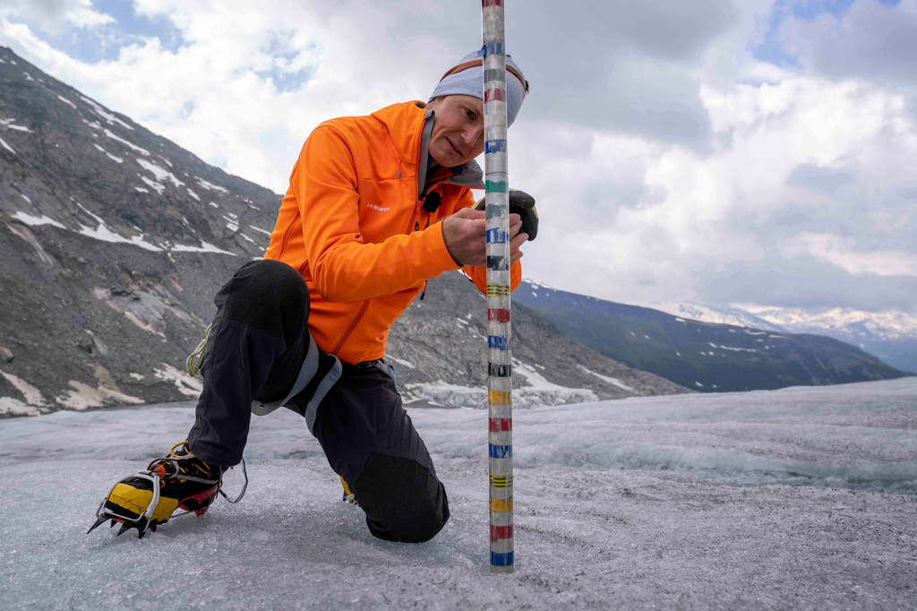 FILE - ETH (Swiss Federal Institute of Technology) glaciologist and head of the Swiss measurement network Glamos, Matthias Huss, checks the thickness of the Rhone Glacier near Goms, Switzerland, June 16, 2023. (AP Photo/Matthias Schrader, File)