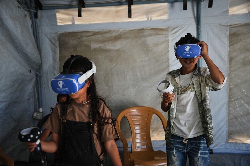 Palestinian children participate in a psychological support session using a virtual reality headset in a tent operated by a medical technology team in Zawaida, central Gaza Strip, Wednesday, June 17, 2026. (AP Photo/Abdel Kareem Hana)