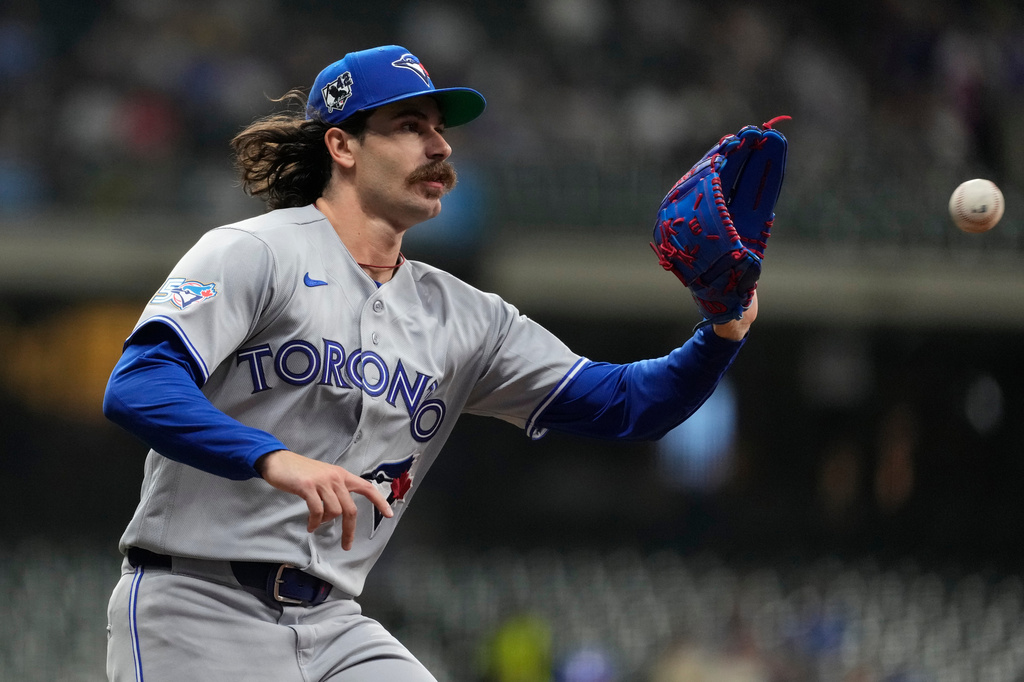 Toronto Blue Jays' Dylan Cease catches the ball at first base to force an out during the second inning of a baseball game against the Milwaukee Brewers, Wednesday, April 15, 2026, in Milwaukee. (AP Photo/Aaron Gash)