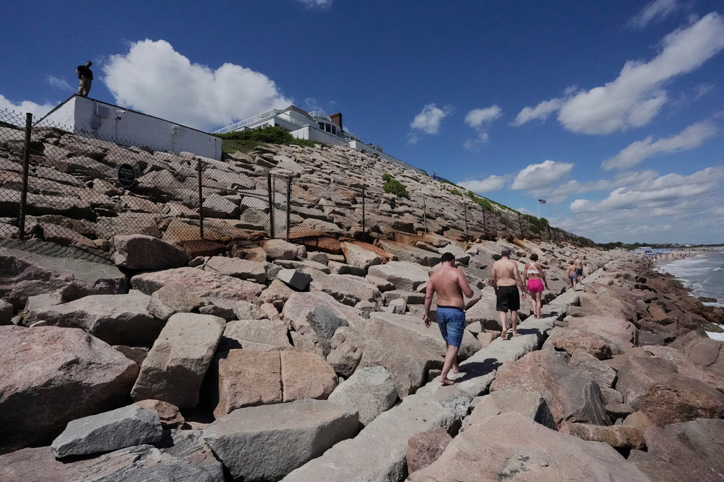 Beach-goers walk on a seawall below Taylor Swift house, Saturday, June 20, 2026, in Westerly, R.I. (AP Photo/Robert F. Bukaty)