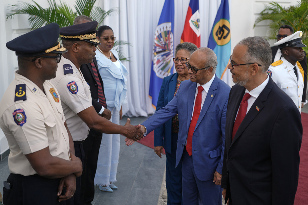 Haiti's Prime Minister Alix Didier Fils-Aimé, far right, Secretary General of the Organization of American States (OAS), Albert Ramdin, second from right, and CARICOM Secretary-General Carla Barnett greet senior police officials at the National Palace in Port-au-Prince, Haiti, Monday, Aug. 17, 2026. (AP Photo/Odelyn Joseph)