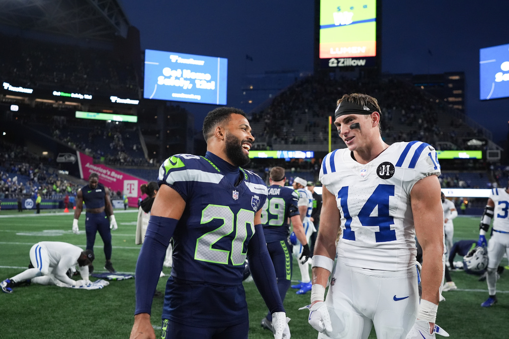 Seattle Seahawks safety Julian Love (20) talks with Indianapolis Colts wide receiver Alec Pierce (14) after an NFL football game Sunday, Dec. 14, 2025, in Seattle. (AP Photo/Lindsey Wasson)