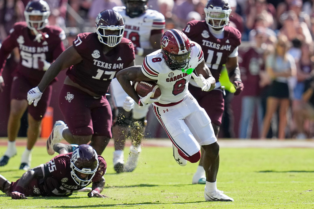 South Carolina wide receiver Nyck Harbor (8) catches a pass for a touchdown as Texas A&M defensive tackle Albert Regis (17) and Dalton Brooks (25) defend during the first half of an NCAA college football game Saturday, Nov. 15, 2025, in College Station, Texas. (AP Photo/David J. Phillip)