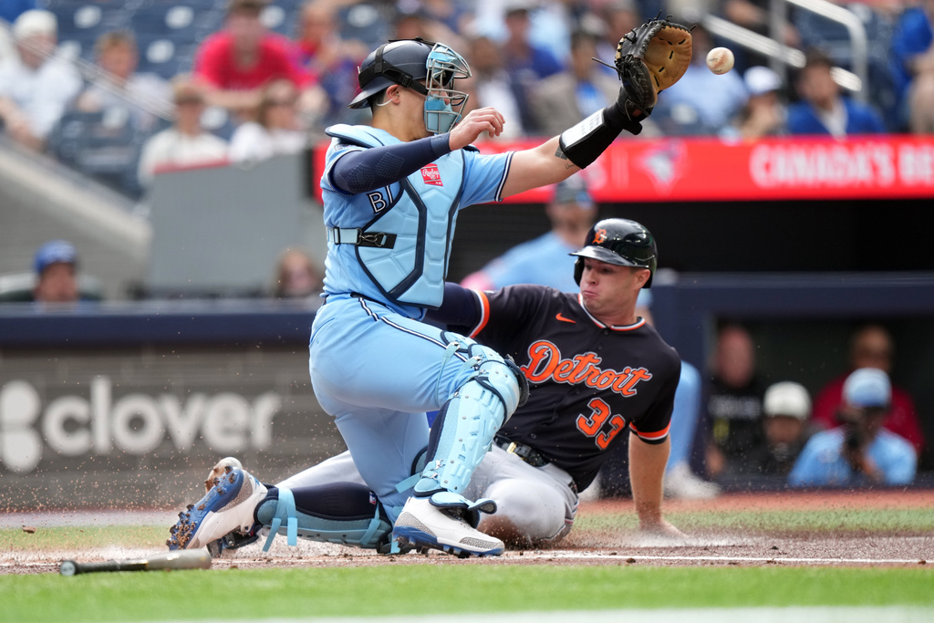 Toronto Blue Jays catcher Brandon Valenzuela (59) tries to tag out Detroit Tigers' Colt Keith (33) as he scores a run during the first inning of a baseball game in Toronto, Wednesday, Sept. 16, 2026. (Nathan Denette/The Canadian Press via AP)