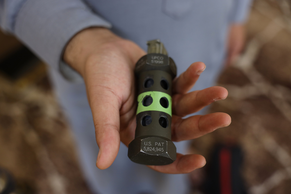 A relative of Khaled al-Masoud holds a piece of a munition said to have been used in the raid that killed him, in the town of Dumayr, in the Damascus countryside, Syria, Oct. 28, 2025. (AP Photo/Omar Albam)