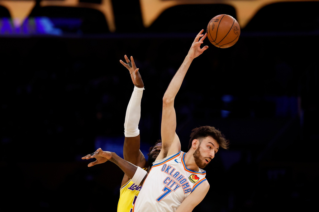 Oklahoma City Thunder center Chet Holmgren (7) reaches for possession of the ball while being guarded by Los Angeles Lakers center Deandre Ayton (5) during the first half of an NBA basketball game Tuesday, April 7, 2026, in Los Angeles. (AP Photo/Caroline Brehman)