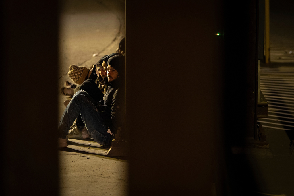 A group of migrants wait to be processed between two border walls separating Mexico and the United States after crossing illegally before dawn, Jan. 21, 2025, in San Diego. (AP Photo/Gregory Bull, File)