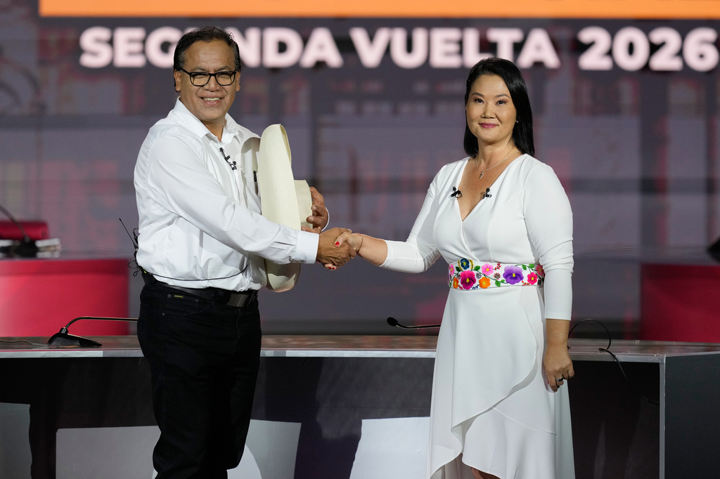 Presidential candidate Keiko Fujimori of the Popular Force party, right, shakes hands with rival Roberto Sanchez of Together for Peru party, before a presidential debate, in Lima, Peru, Sunday, May 31, 2026. (AP Photo/Martin Mejia)