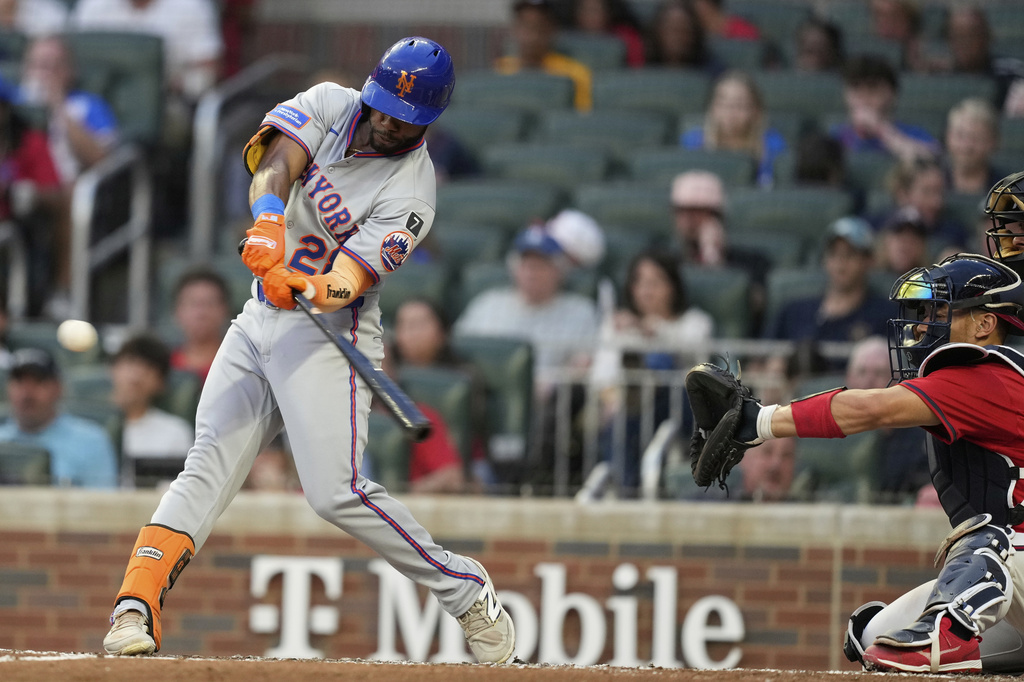 New York Mets' Cedric Mullins (28) hits a triple in the third inning of a baseball game against the Atlanta Braves, Friday, Aug. 22, 2025, in Atlanta. (AP Photo/Brynn Anderson)