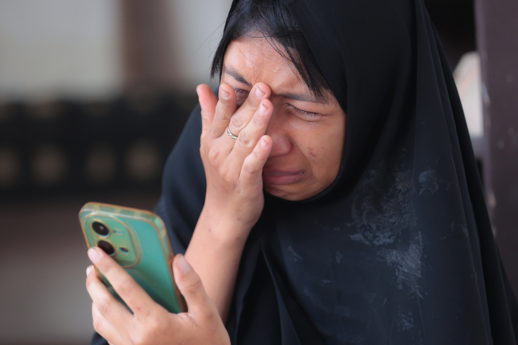 A woman weeps as rescue works are underway for victims trapped under the rubble after a building under construction collapsed at an Islamic boarding school in Sidoarjo, East Java, Indonesia, Wednesday, Oct. 1, 2025. (AP Photo/Trisnadi)