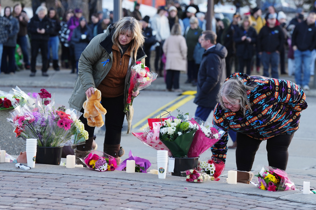 People bring flowers and stuffed animal to a vigil for the victims of a mass shooting, in Tumbler Ridge, B.C., Friday, Feb. 13, 2026. (Christinne Muschi/The Canadian Press via AP)