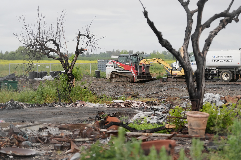A service vehicle drives near damaged property at the location of a July 1, 2025, fireworks explosion in Esparto, Calif., Friday, April 10, 2026. (AP Photo/Jeff Chiu)