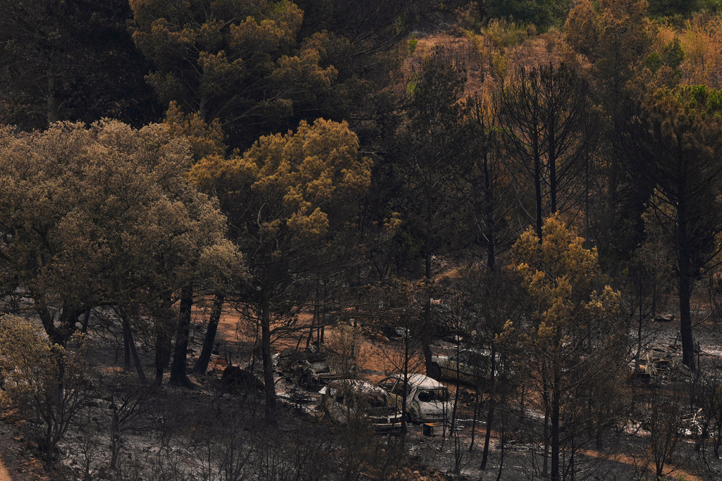 Cars and burned trees are pictured during one of the largest wildfire in decades in Fontjoncouse, southern France, Friday, Aug. 8, 2025. (AP Photo/Manu Fernandez)