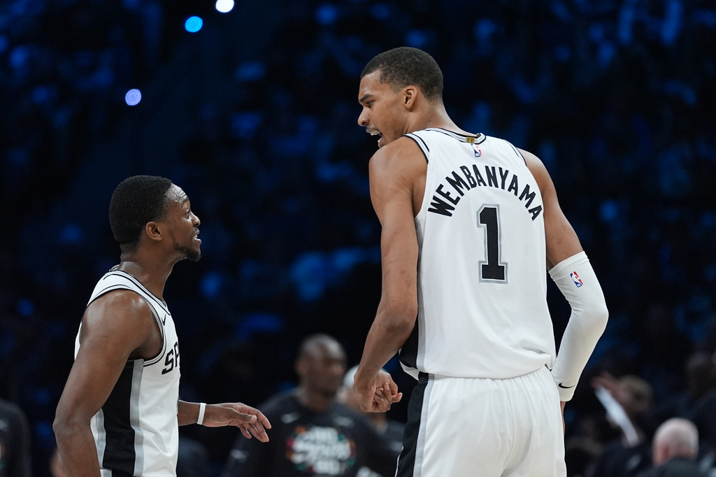 San Antonio Spurs forward Victor Wembanyama (1) celebrates a score with guard De'aaron Fox (4) during the first half of Game 6 of an NBA basketball second-round playoffs series in Minneapolis, Friday, May 15, 2026. (AP Photo/Abbie Parr)