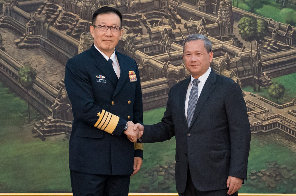 In this photo released by Agence Kampuchea Press (AKP), Chinese Defense Minister Dong Jun, left, shakes hands with Cambodian Prime Minister Hun Manet prior to a meeting at Peace Palace in Phnom Penh, Cambodia, Wednesday, April 22, 2026. (Agence Kampuchea Press via AP)