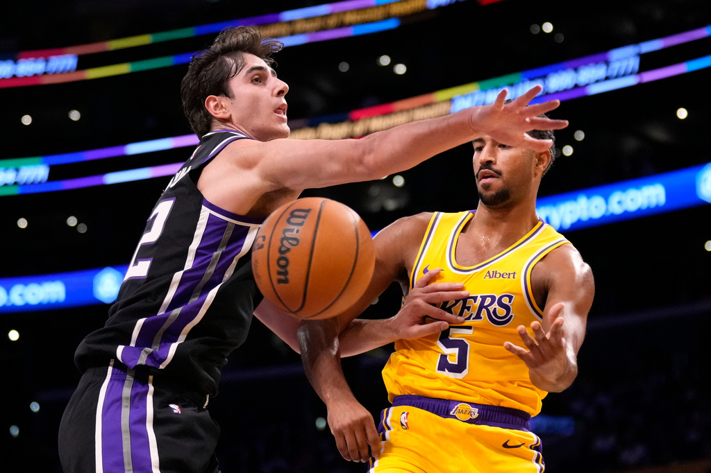 Los Angeles Lakers guard Quentin Grimes, right, passes past Sacramento Kings center Maxime Raynaud during the first half of a preseason NBA basketball game Thursday, Oct. 8, 2026, in Los Angeles. (AP Photo/Mark J. Terrill)