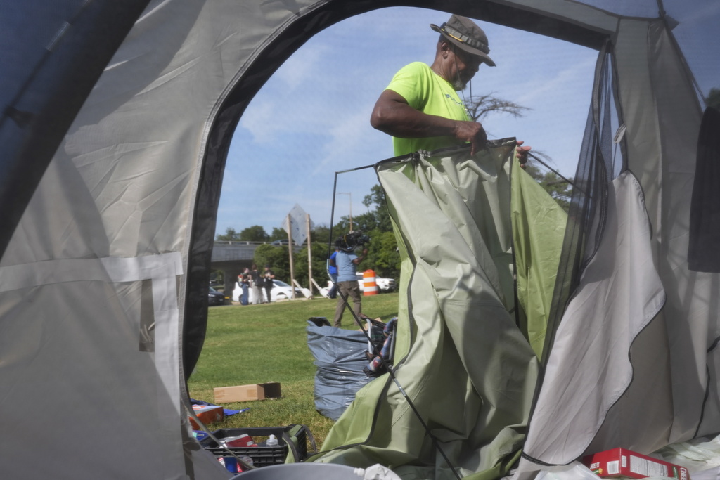 George M., who has been living at a tent encampment, packs up his tent, Thursday, Aug. 14, 2025 in Washington. (AP Photo/Jacquelyn Martin)