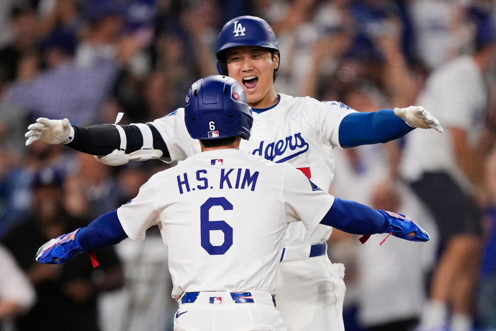 Los Angeles Dodgers' Hyeseong Kim (6) celebrates with Shohei Ohtani after scoring the game-winning run on a ground ball from Andy Pages and throwing error from Philadelphia Phillies relief pitcher Orion Kerkering during the eleventh inning in Game 4 of baseball's National League Division Series Thursday, Oct. 9, 2025, in Los Angeles. (AP Photo/Mark J. Terrill)