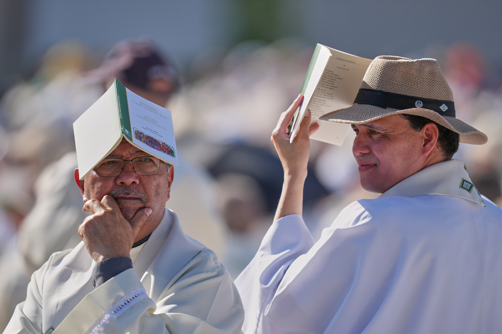 Priests wait for the arrival of Pope Leo XIV ahead of a Holy Mass and Corpus Christi procession at Plaza de Cibeles in Madrid, Spain, Sunday, June 7, 2026, on the second day of his seven-day apostolic visit to mainland Spain and the Canary Islands. (AP Photo/Manu Fernandez)