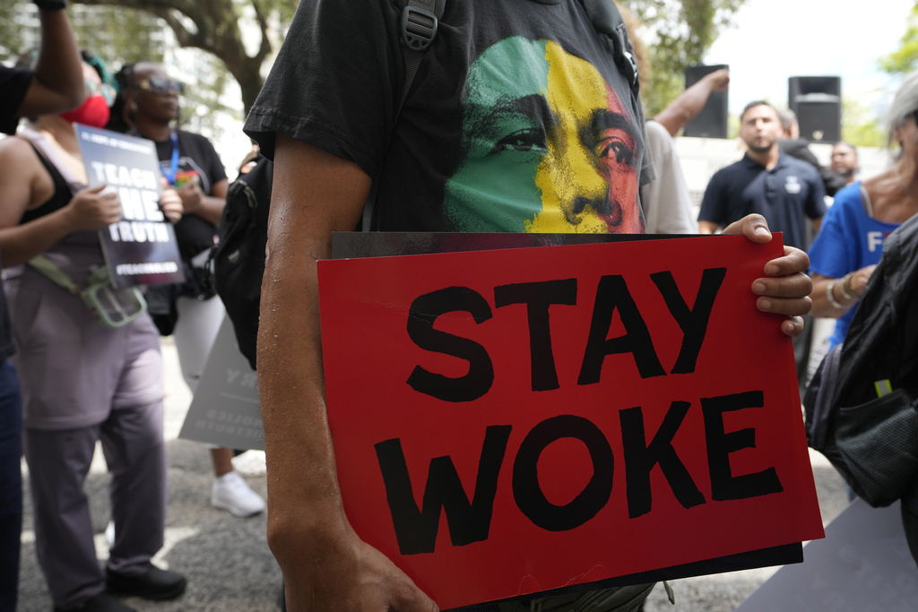 FILE - A person carries a sign during a march to protest Florida's new standards for teaching Black history, Aug. 16, 2023, in Miami. (AP Photo/Lynne Sladky, File)