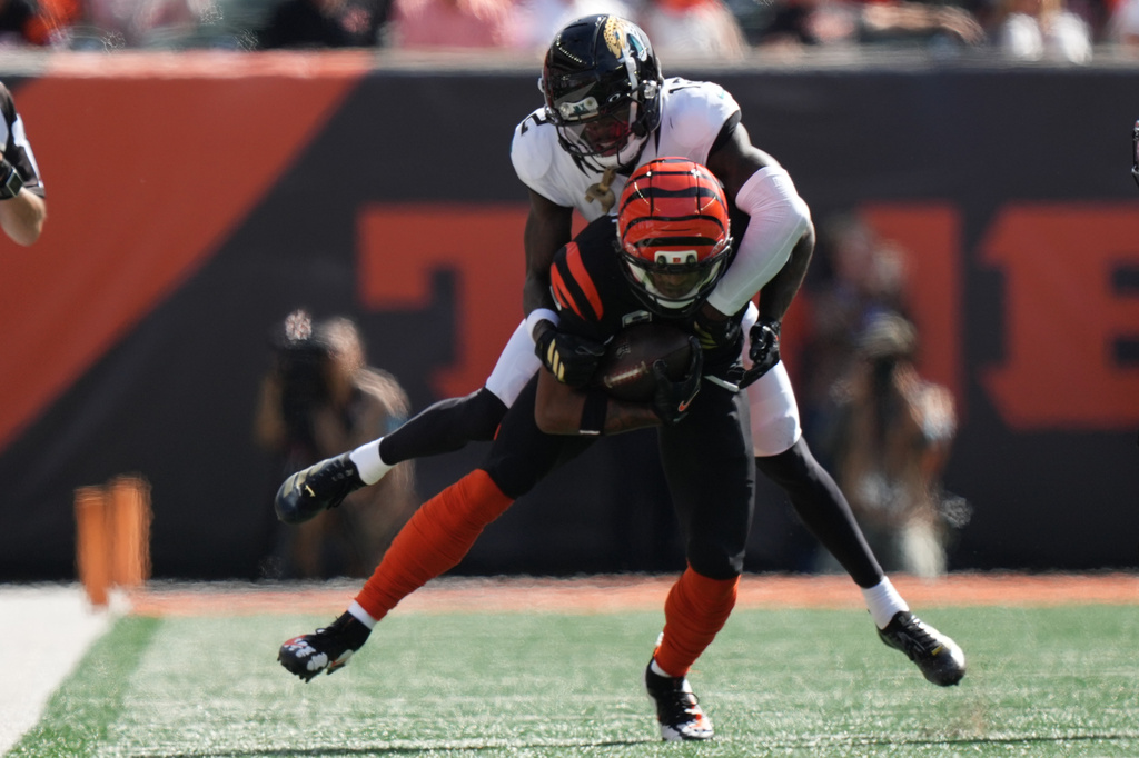 Jacksonville Jaguars cornerback Travis Hunter (12) tackles Cincinnati Bengals wide receiver Ja'marr Chase (1) during an NFL football game in Cincinnati, Sunday, Oct. 4, 2026. (AP Photo/Joshua A. Bickel)
