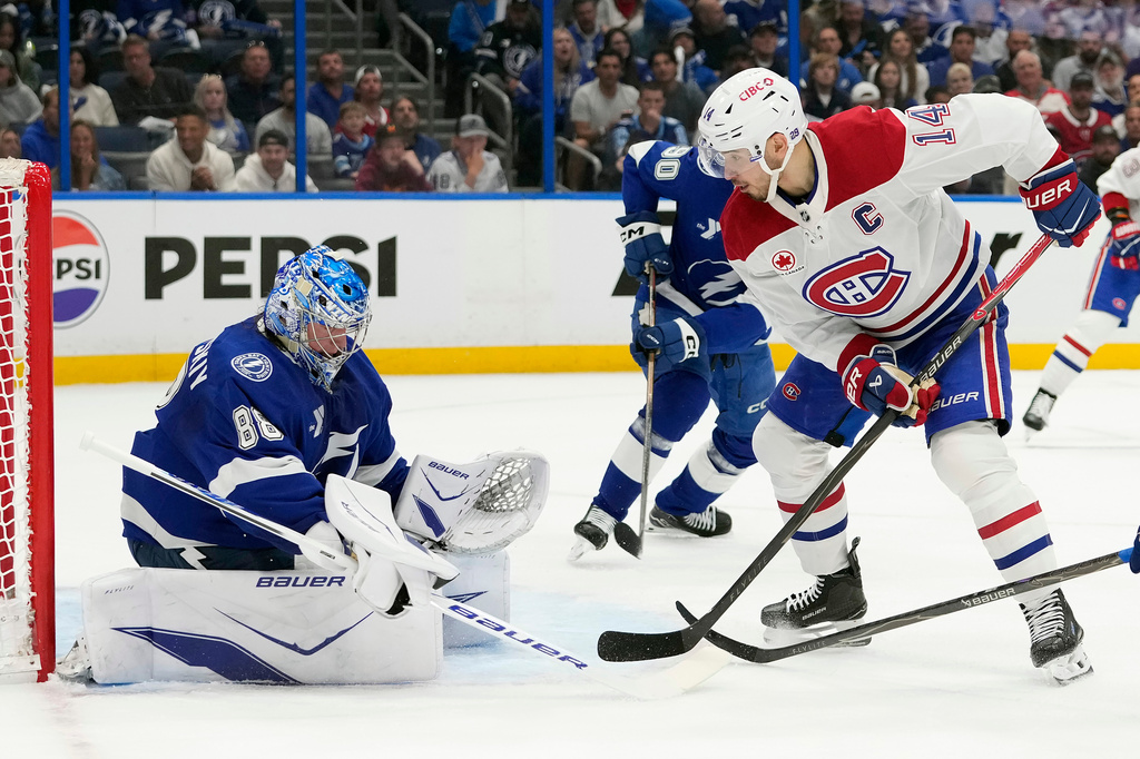 Montréal Canadiens center Nick Suzuki (14) deflects the puck on Tampa Bay Lightning goaltender Andrei Vasilevskiy (88) during the first period in Game 2 of an NHL hockey Stanley Cup first-round playoff series, Tuesday, April 21, 2026, in Tampa, Fla. (AP Photo/Chris O'Meara)