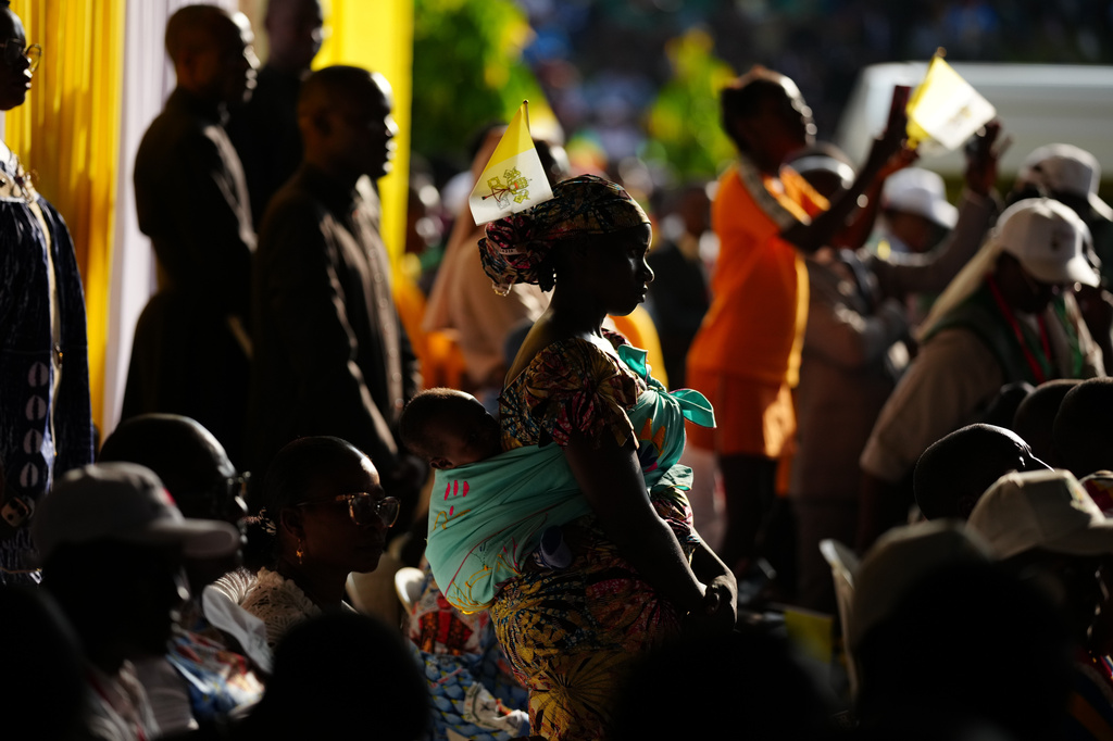 A woman with her child attends Pope Leo XIV's meeting with University students and professors at the Catholic University of Central Africa, in Yaounde Cameroon, Friday, April 17, 2026. (AP Photo/Andrew Medichini)