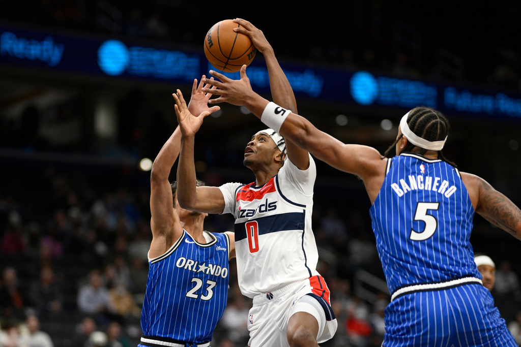 Washington Wizards guard Bilal Coulibaly (0) goes to the basket against Orlando Magic forward Paolo Banchero (5) and forward Tristan da Silva (23) during the first half of an NBA basketball game, Tuesday, Jan. 6, 2026, in Washington. (AP Photo/Nick Wass)