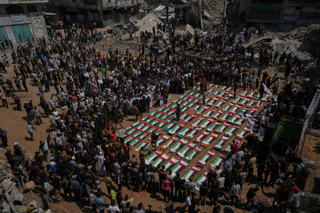 Bodies of members of the Hassayna and Abu Sharia families, killed in an Israeli strike in 2023 and recently recovered from the rubble, are draped in Palestinian flags during their funeral in Gaza City, Tuesday, Aug. 4, 2026. (AP Photo/Jehad Alshrafi)