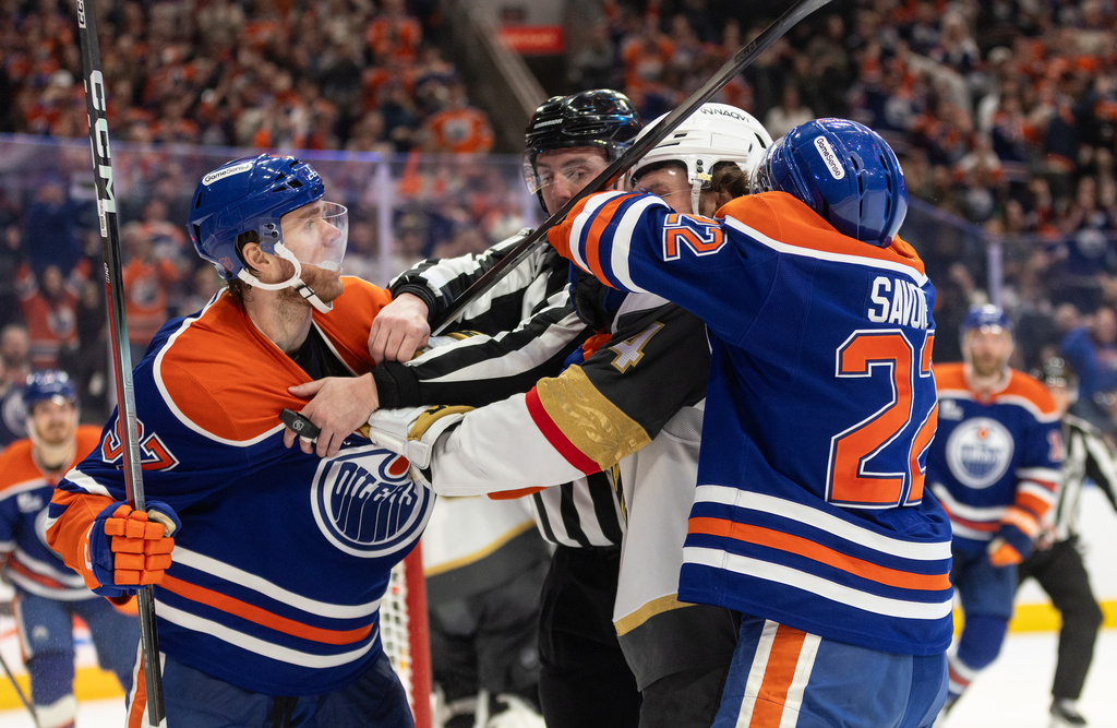 Vegas Golden Knights' Rasmus Andersson (4) roughs it up with Edmonton Oilers' Connor McDavid (97) and Matt Savoie (22) during the second period of an NHL hockey game in Edmonton, Alberta, on Saturday April 4, 2026. (Jason Franson/The Canadian Press via AP)