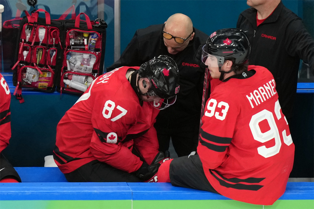 Canada's Sidney Crosby (87) is attended to after being injured during the second period of a men's ice hockey quarterfinal game between Canada and Czechia at the 2026 Winter Olympics, in Milan, Italy, Wednesday, Feb. 18, 2026. (AP Photo/Hassan Ammar)