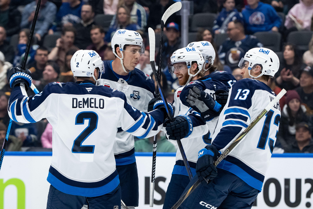 Winnipeg Jets' Kyle Connor, center, celebrates his goal against the Vancouver Canucks with Dylan DeMelo (2), Logan Stanley (64), Mark Scheifele (55), and Gabriel Vilardi (13) during the first period of an NHL hockey game in Vancouver, B.C., on Wednesday, Feb. 25, 2026. (Ethan Cairns/The Canadian Press via AP)